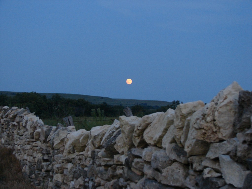 Full Moon and Stone Fence. Moon Over Sunlit Hills (and remnants of stone fence). Photo credit by Nancy Crenshaw-Miller.