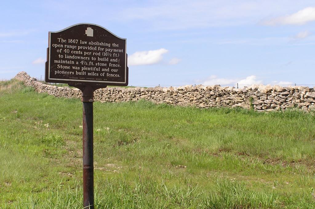 Signpost along side original stone fence in Wabaunsee County. Photo credit Nancy Crenshaw-Miller.